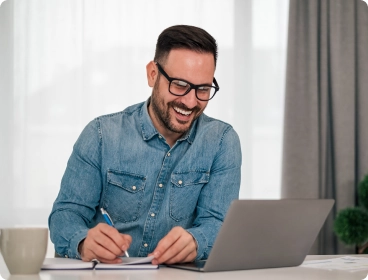 perguntas frequentes homem sorrindo em frente ao computador